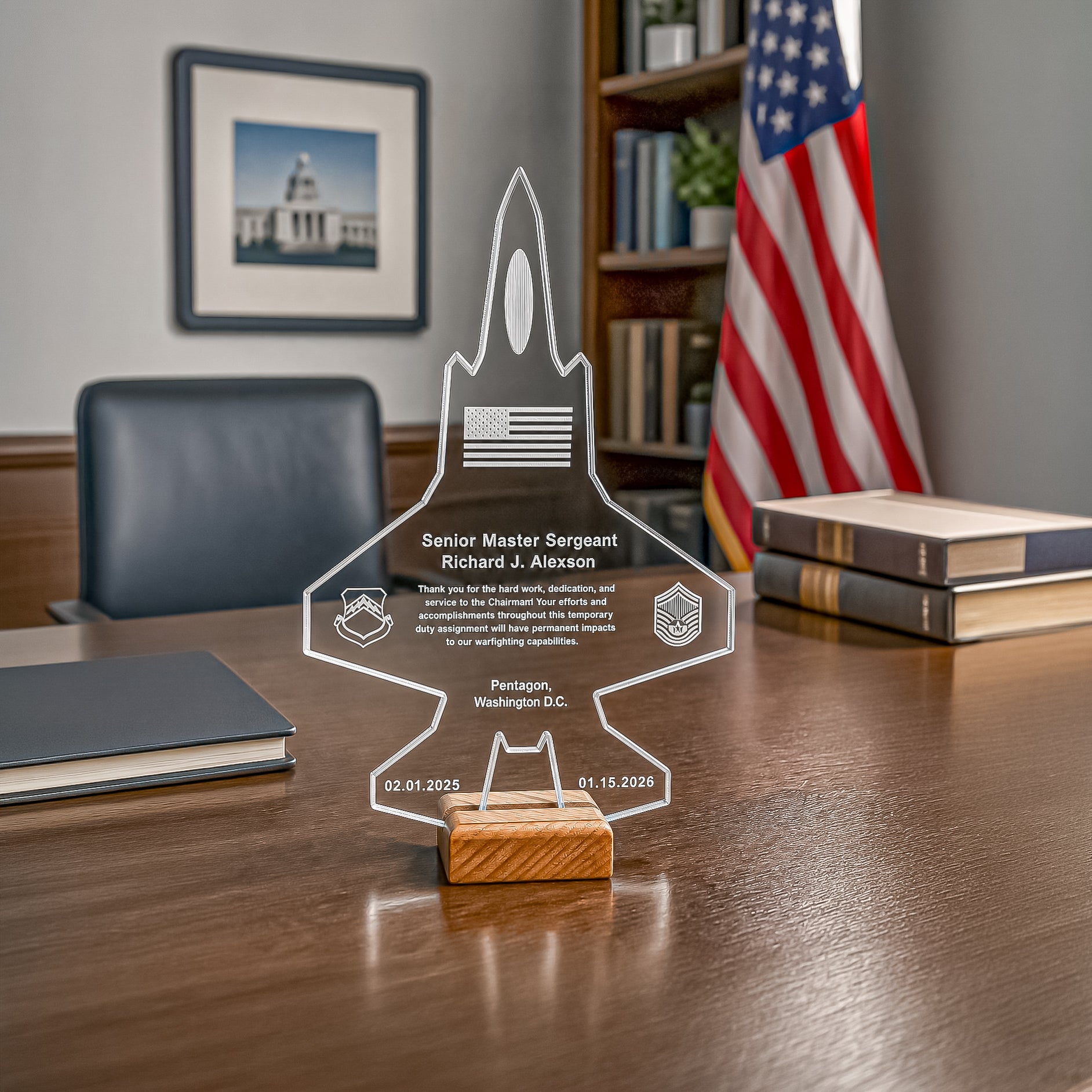 A clear acrylic jet-shaped keepsake plaque with engraved personal details and a small wooden base, displayed on a wooden desk in an office setting with a U.S.
