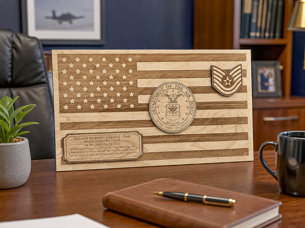 A personalized wooden plaque featuring an engraved American flag design, a circular military emblem, and a chevron insignia, displayed on a wooden desk in an office setting.