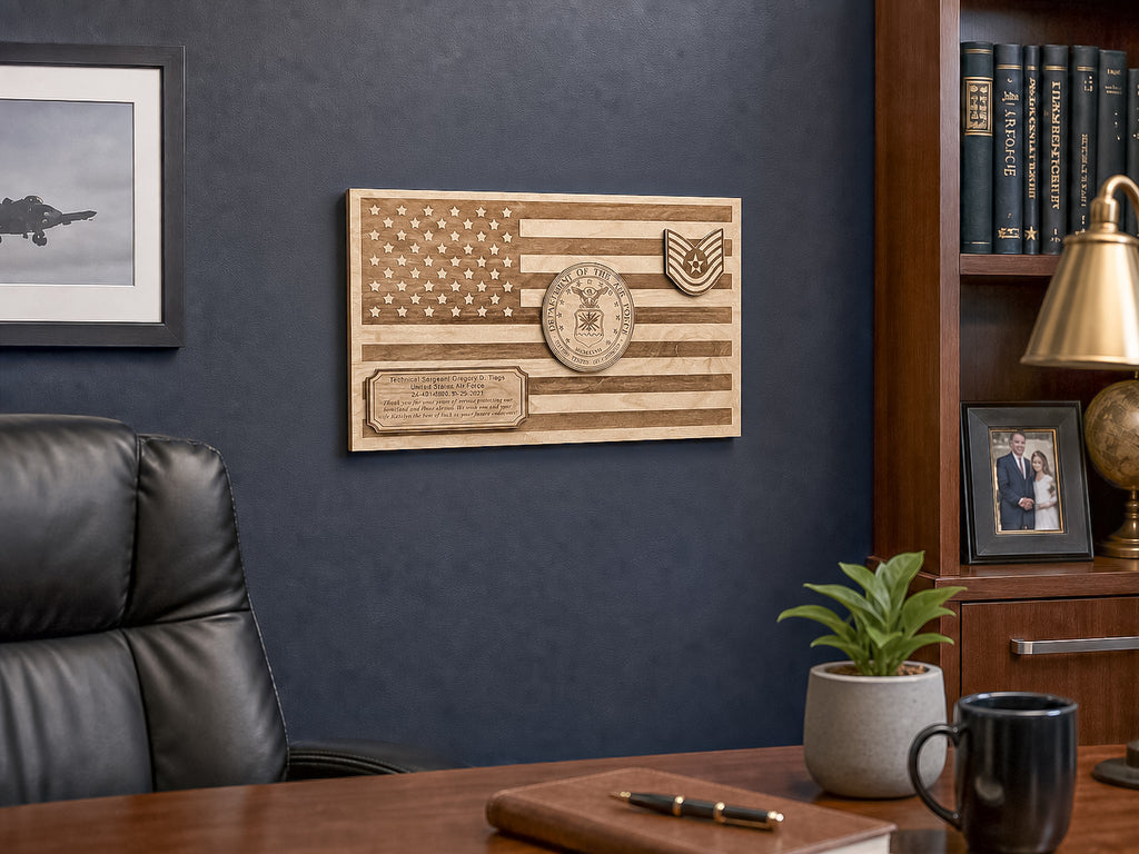 A personalized wooden American flag wall plaque with military insignia and a nameplate, mounted on a dark blue wall in an office setting.